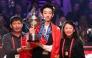 China's Wu Yize (C) holds the championship trophy as he poses with his parents during the awards ceremony after his victory over England's Shaun Murphy in the World Snooker Championship final round at The Crucible in Sheffield, northern England on May 4, 2026. (Photo by Darren Staples / AFP)