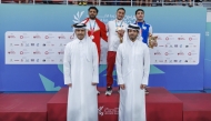 Secretary General of the Qatar Olympic Committee and Vice Chairman of the Organising Committee of the Games Jassim bin Rashid Al Buenain with the podium winners of the men’s 200m individual medley, won by Qatar's Mohamed Mahmoud.