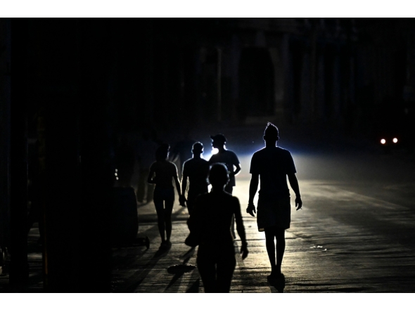 People walk on a street during a blackout in Havana, Cuba. (Photo by Yamil Lage / AFP)