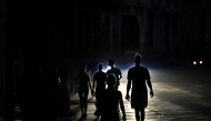 People walk on a street during a blackout in Havana, Cuba. (Photo by Yamil Lage / AFP)