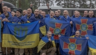 Released Ukrainian prisoners of war (POWs) react as they pose for a group photograph following a prisoner exchange at an undisclosed location, in the Chernihiv region on May 15, 2026. (Photo by Roman PILIPEY / AFP)