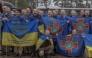 Released Ukrainian prisoners of war (POWs) react as they pose for a group photograph following a prisoner exchange at an undisclosed location, in the Chernihiv region on May 15, 2026. (Photo by Roman PILIPEY / AFP)