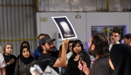 Habeeb Abu-Futtaim (holding the image) and Yousef Bahzad (with the mic) are previewing the artwork. Pic: Maria Ovsyannikova