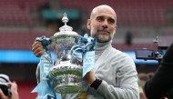 Manchester City's Spanish manager Pep Guardiola poses with the trophy on the pitch after the English FA Cup final football match between Chelsea and Manchester City at Wembley stadium in London, on May 16, 2026. Photo by ADRIAN DENNIS / AFP