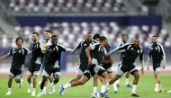 Qatar players take part in a training session. RIGHT: Coach Julen Lopetegui reacts during the session.