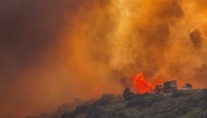 Fire fighters use a bulldozer to combat the Sandy Fire as it burns on a hill at a residential area in Simi Valley, California (Photo by Apu Gomes / AFP)
