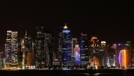 Illuminated skyscrapers are pictured along the corniche promenade in Doha on May 15, 2026. (Photo by Karim JAAFAR / AFP)
