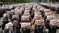 Members of the Samsung Electronics labour union hold signs reading 