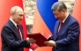 In this pool photograph distributed by the Russian state agency Sputnik, Russia's President Vladimir Putin and China's President Xi Jinping exchange documents during a signing ceremony following their talks in Beijing on May 20, 2026. (Photo by Alexander Kazakov / POOL / AFP)
