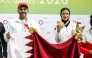 Qatar's Saeed Abu Sharib and Maytha Al-Binali celebrate on the podium after winning the mixed team trap gold. 