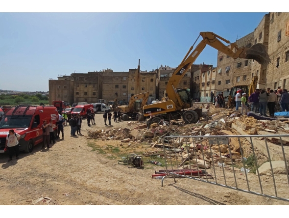 Rescuers search through the rubble of a four-storey building that collapsed overnight in the Moroccan city of Fes, on May 21, 2026. (Photo by Abdelmajid Bziouat / AFP)
