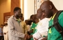 President of Senegal Bassirou Diomaye Faye (L) shakes hands with Senegalese supporters who were granted a royal pardon in Morocco as they arrive at Blaise Diagne International Airport in Ndiass, Senegal (Photo by Seyllou / AFP)