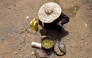 Displaced Yemeni woman Saeedah Mohammed boils tree leaves to feed her grand-children outside their makeshift tent in the Al-Manij displacement camp, near the city of Taez in Yemen's southwest, on May 21, 2026. (Photo by Ahmed al-Basha / AFP)