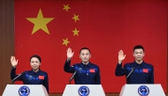 Astronauts for China's Shenzhou-23 space mission Lai Ka-ying (L), Zhu Yangzhu (C) and Zhang Zhiyuan (R) wave during a press conference before the launch of the mission at the Jiuquan Satellite Launch Center in the Gobi desert in Jiuquan, in northwestern China's Gansu province on May 23, 2026. (Photo by CNS / AFP)