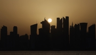 Skyscraper buildings are silhouetted against the setting sun in Doha on May 24, 2026. (Photo by Karim Jaafar / AFP)