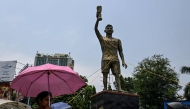 Commuters walk past a statue of Argentine football player Lionel Messi in Kolkata on May 27, 2026. (Photo by Dibyangshu Sarkar / AFP)