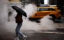 A woman holding an umbrella crosses the street in the rain in New York City, on May 24, 2026. Photo by CHARLY TRIBALLEAU / AFP