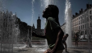 Children cool off in a fountain in Lyon on May 27, 2026 as a heatwave hits France. (Photo by Jeff Pachoud/ AFP)