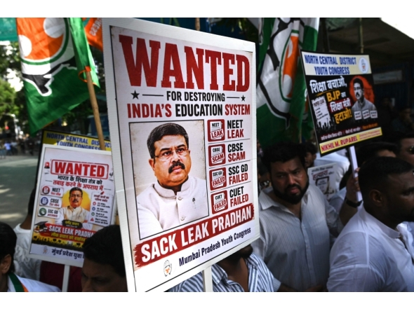 Indian Youth Congress party workers hold placards of India's Education Minister Dharmendra Pradhan during a protest against National Testing Agency (NTA) in Mumbai on June 2, 2026. (Photo by Indranil Mukherjee / AFP)