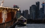 Traditional wooden boats are pictured against the backdrop of illuminated skyscrapers along the Corniche promenade in Doha on May 31, 2026. (Photo by Karim JAAFAR / AFP)
