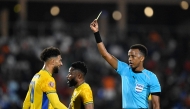Gabon's forward #20 Denis Bouanga is shown the yellow card by Somali referee Omar Abdulkadir Artan during the Africa Cup of Nations (CAN) Group F football match between Gabon and Ivory Coast at the Grand Stadium in Marrakech on December 31, 2025. Photo by KHALED DESOUKI / AFP