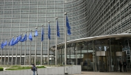 A woman rides an electric scooter past the Berlaymont building, the EU Commission headquarters, in Brussels on June 9, 2026. (Photo by Nicolas Tucat / AFP)
