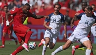 Canada's forward #09 Cyle Larin (L) scores the equalizer during the 2026 World Cup Group B football match between Canada and Bosnia and Herzegovina at the Toronto Stadium in Toronto on June 12, 2026. (Photo by Cole Burston / AFP)