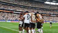 Germany's defender #18 Nathaniel Brown (C) celebrates with teammates after scoring his team's fifth goal during the 2026 World Cup Group E football match between Germany and Curacao at the Houston Stadium in Houston on June 14, 2026.
(Photo by RONALDO SCHEMIDT / AFP)