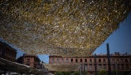 People walk through the Capitole square covered by an installation to provide shade, in Toulouse on June 19, 2026. Photo by Lionel BONAVENTURE / AFP