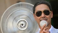 A guest holds a mini-fan to cool down before the Thom Browne collection show at Milan's Fashion Week Menswear Spring/Summer 2027, in Milan on June 22, 2026. (Photo by Stefano RELLANDINI / AFP)