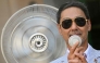 A guest holds a mini-fan to cool down before the Thom Browne collection show at Milan's Fashion Week Menswear Spring/Summer 2027, in Milan on June 22, 2026. (Photo by Stefano RELLANDINI / AFP)