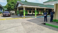 Policemen stand near the crime scene of a school compound after a shooting incident at a high school compound in Tacloban City, Leyte province on June 22, 2026. (Photo by Noel Sianosa / AFP)