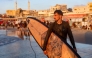 Palestinian surfer Tahseen Abu Assi, 23, takes his surfboard out into the Mediterranean sea off a beach in Gaza City on June 21, 2026. (Photo by Omar Al-Qattaa / AFP)