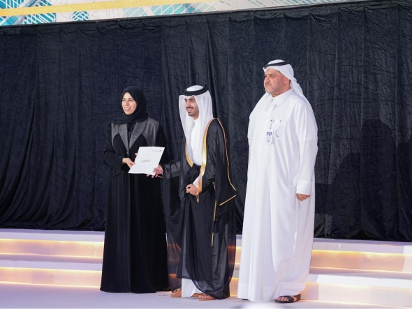 Minister of Education and Higher Education H E Lolwah bint Rashid bin Mohammed Al Khater honouring a graduate of Qatar School for Science and Technology for Boys during a ceremony.
