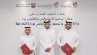Minister of Justice and Minister of State for Cabinet Affairs H E Ibrahim bin Ali Al Mohannadi with officials from the two entities during the signing ceremony.