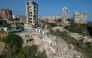 This aerial view shows collapsed buildings in Catia La Mar, La Guaira state, Venezuela, on June 27, 2026, following earthquakes that struck the region. Nearly 1,000 people have been killed and more than 50,000 remain missing after two consecutive earthquakes in Venezuela, where growing anger has been reported over the lack of official aid to swiftly rescue survivors. (Photo by Federico PARRA / AFP)
