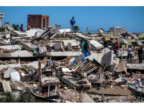 Volunteers and residents search for survivors on the rubble of collapsed buildings in Caraballeda, La Guaira state, Venezuela, on June 28, 2026, following earthquakes. Photo by Miguel MEDINA / POOL / AFP