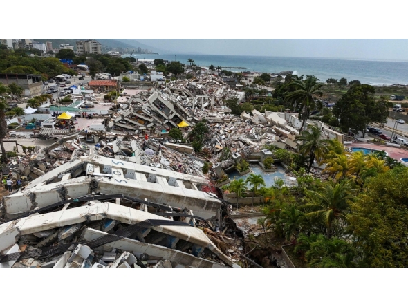 This aerial view taken on July 2, 2026, in Caraballeda in the state of La Guaira shows collapsed buildings following the June 24 twin earthquakes. (Photo by Miguel Medina / Pool / AFP)
