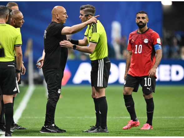 Egypt's head coach Hossam Hassan speaks with French referee Francois Letexier as Egypt's forward #10 Mohamed Salah looks on. (Photo by Roberto Schmidt / AFP)