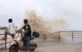 People look on as large waves crash against the coast amid weather patterns from approaching Typhoon Bavi in Wenling city, Taizhou, China's eastern Zhejiang province on July 10, 2026. (Photo by CN-STR / AFP)
 