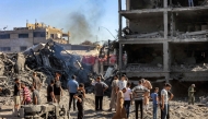 People gather by the rubble of destroyed buildings following an Israeli strike on an industrial area in Gaza City on July 12, 2026. (Photo by Omar Al-Qattaa / AFP)
