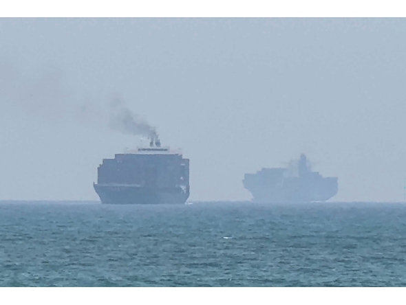 This frame grab taken from AFPTV video footage on July 12, 2026, shows cargo ships anchoring near the Strait of Hormuz off the eastern coast of the United Arab Emirates at Khor Fakkan. (Photo by AFPTV / AFP) 