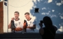 People pose for a photo with a mural of England footballers Jude Bellingham and Morgan Rogers, eating a portion of chips, created by artist Dion Kitson, on the wall of a fish and chip shop near Halesowen in central England, on July 14, 2026. (Photo by Oli Scarff / AFP)