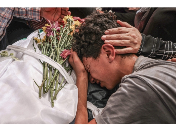 A relative mourns over the body of 17-year-old Fadi al-Naasan during his funeral in the village of Al-Mughayyir, east of Ramallah in the Israeli-occupied West Bank, on July 18, 2026. (Photo by JAAFAR ASHTIYEH / AFP)