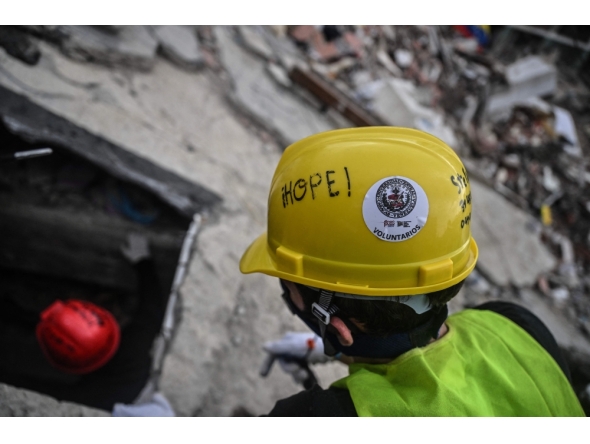 Volunteers and Mexican rescuers search for bodies amid debris of buildings damaged by the June 24 earthquakes, in Tanaguarena, state of La Guaira; Venezuela, on July 18, 2026. (Photo by Juan Barreto / AFP)