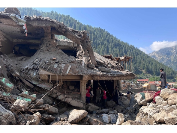 Afghan men search the debris of destroyed shops after flash floods hit Parun town in Afghanistan's Nuristan province, on July 21, 2026. (Photo by AFP)