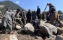 Afghan men search the debris of destroyed shops following flash floods in Parun town in Afghanistan's Nuristan province, on July 21, 2026. (Photo by AFP)