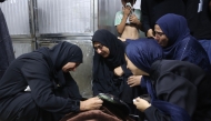 Mourners weep over the body of one of the Palestinian who died after an Israeli airstrike targeted a residential apartment in the Sabra neighborhood of Gaza City on July 21, 2026. (Photo by Omar AL-QATTAA / AFP)