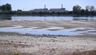 :The dried-up Danube riverbed is pictured with the Paks power plant at the background, near Dunaszentbenedek, close to Paks town on July 31, 2026. (Photo by Attila KISBENEDEK / AFP)