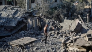 A displaced Palestinian man walks across the debris of buildings destroyed in Israeli attacks in Deir al-Balah, central Gaza Strip on August 1, 2026. (Photo by Eyad Baba / AFP)